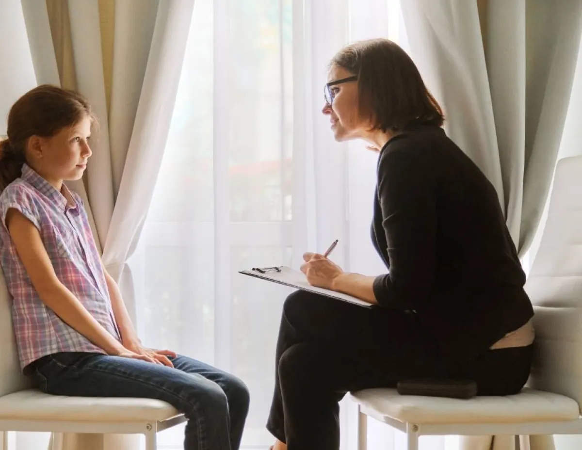 صورة طفلة تتحدث لطبيبة نفسية بسبب السلس الليلي