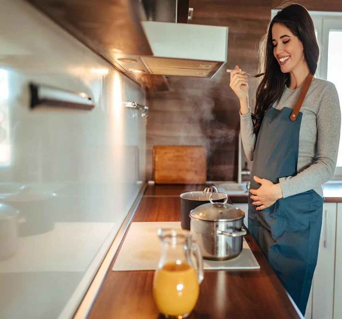 صورة  لحامل تطهو طعامها المفضل