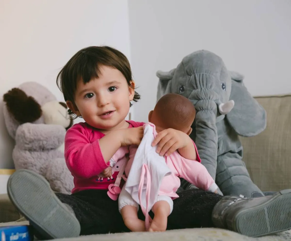صورة لرضيع يلعب بدمية
