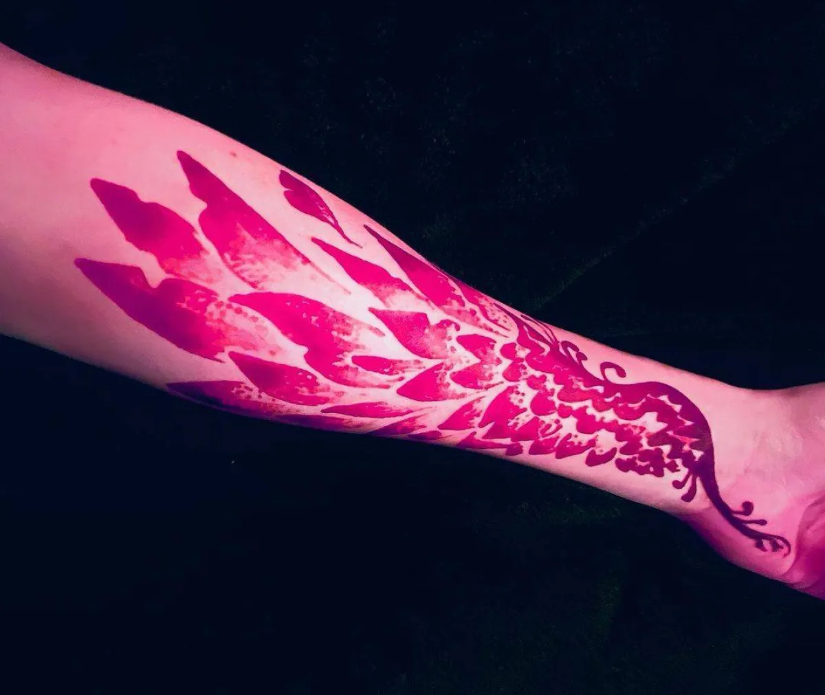 نقش حناء حمراء على شكل طاووس على اليد والذراع