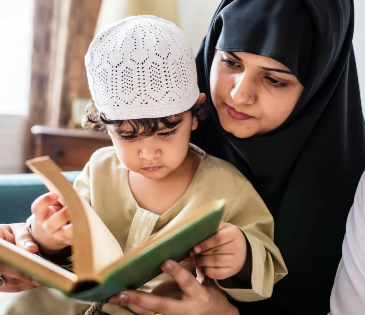 صورة لأم تعلم طفلها قراءة القرآن