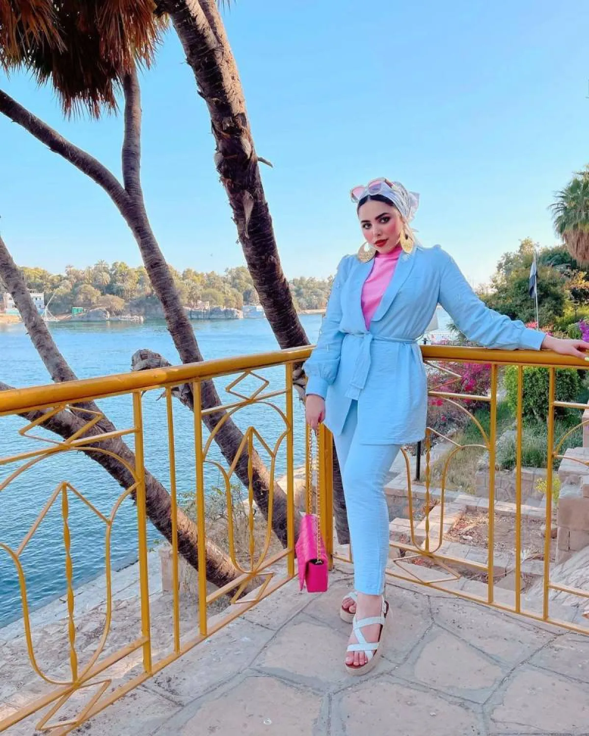 مي محمد ببدلة باللون الأزرق مع توب وردي وحقيبة كتف فوشيا