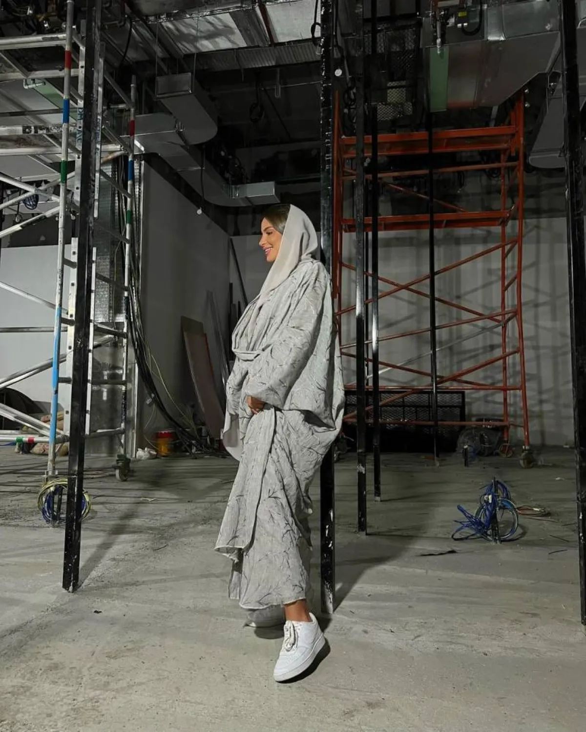 فاطمة حُسام بحذاء رياضي أبيض وعباية باللون الرمادي