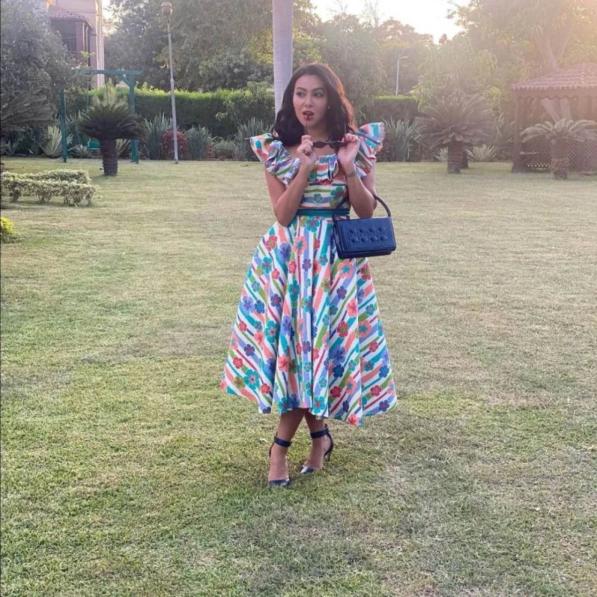 ميريهان حسين بفستان ملون بتنورة منفوشة مع حقيبة يد باللون الأزرق الداكن