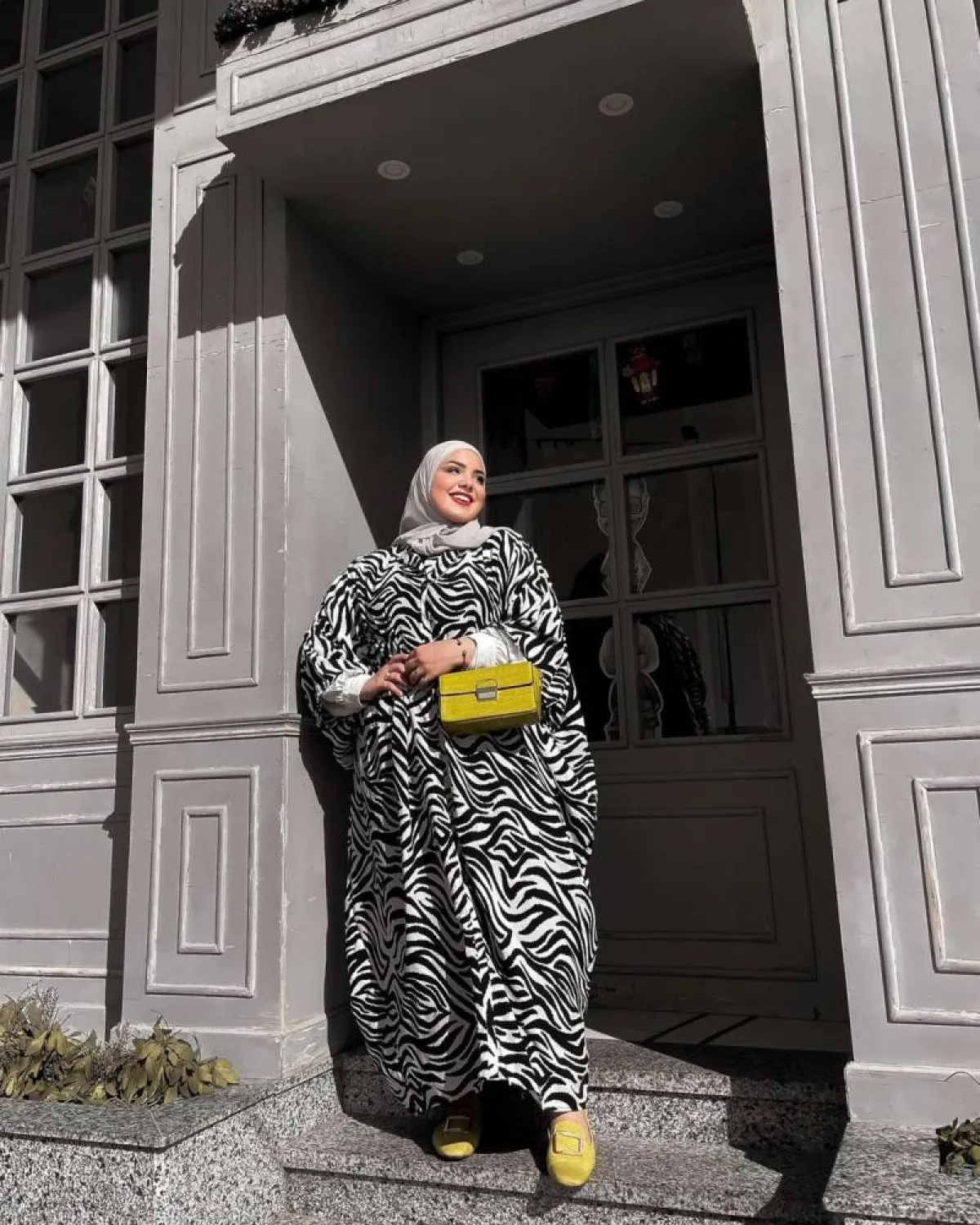 ياسمين وجدي بحقيبة صفراء وفستان باللونين الأبيض والأسود