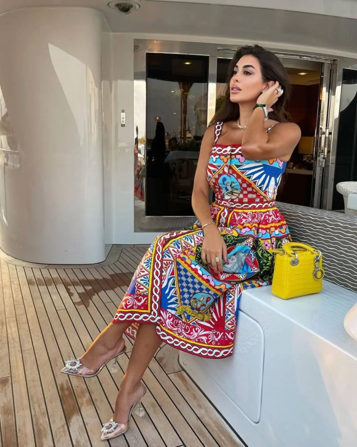 ياسمين صبري بحقيبة مربعة صغيرة باللون الأصفر وفستان مُطبع بالرسوم