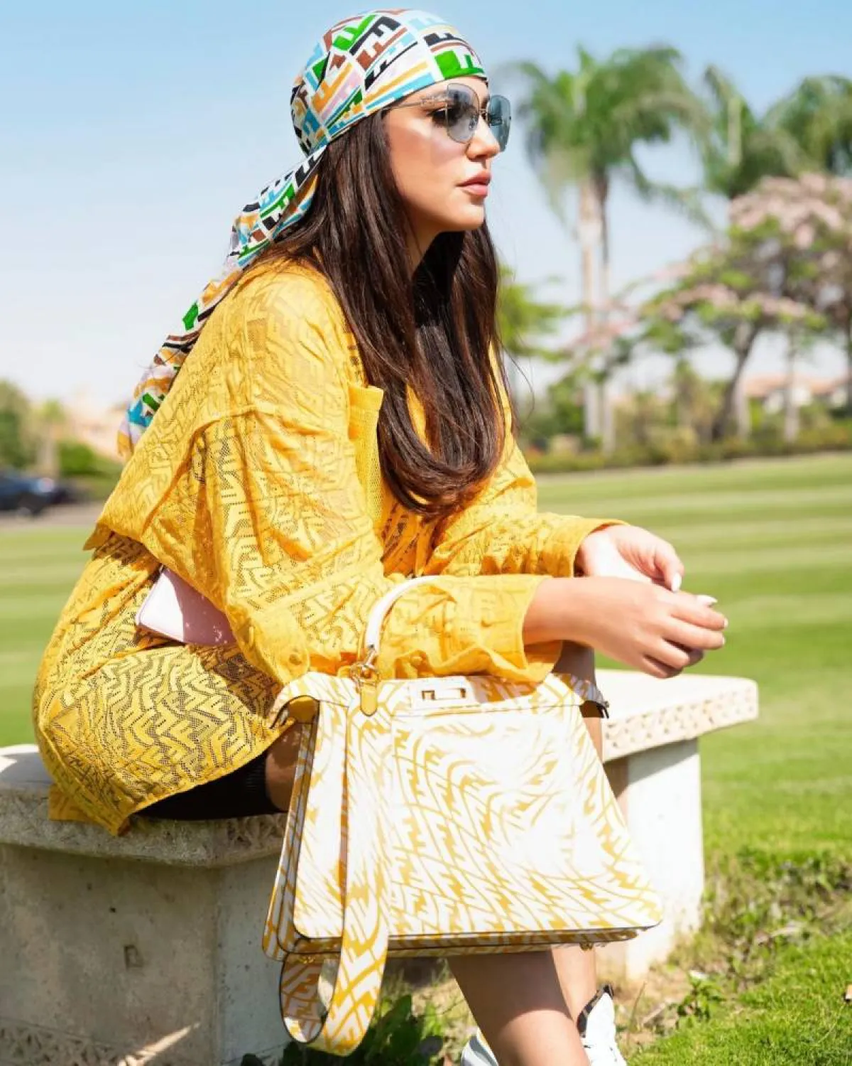 درة زروق بحقيبة باللونين الأبيض والأصفر وتوربان متعدد الألوان