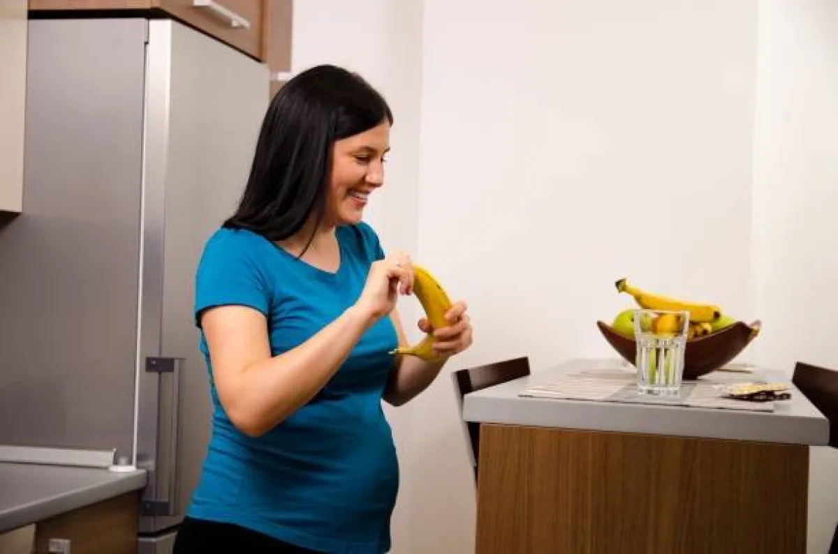 صورة لحامل تستمتع بتناول الموز