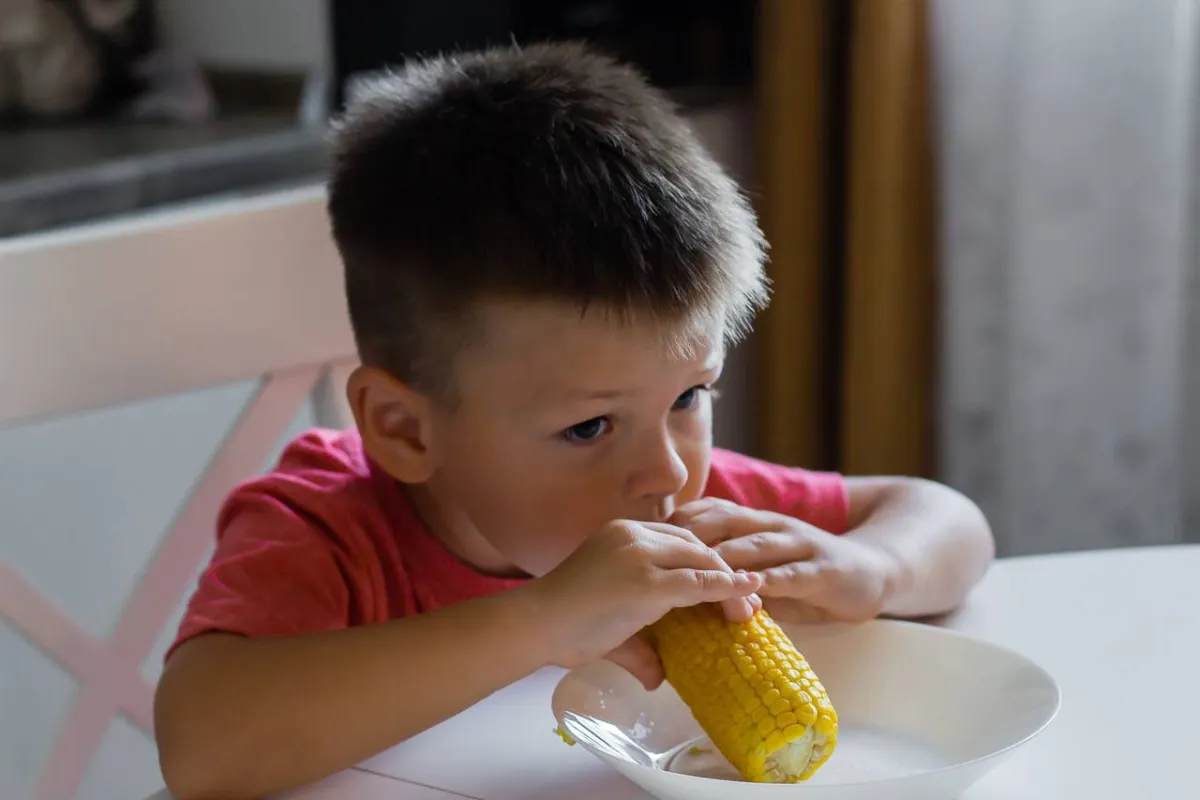 طفل يتناول الذرة