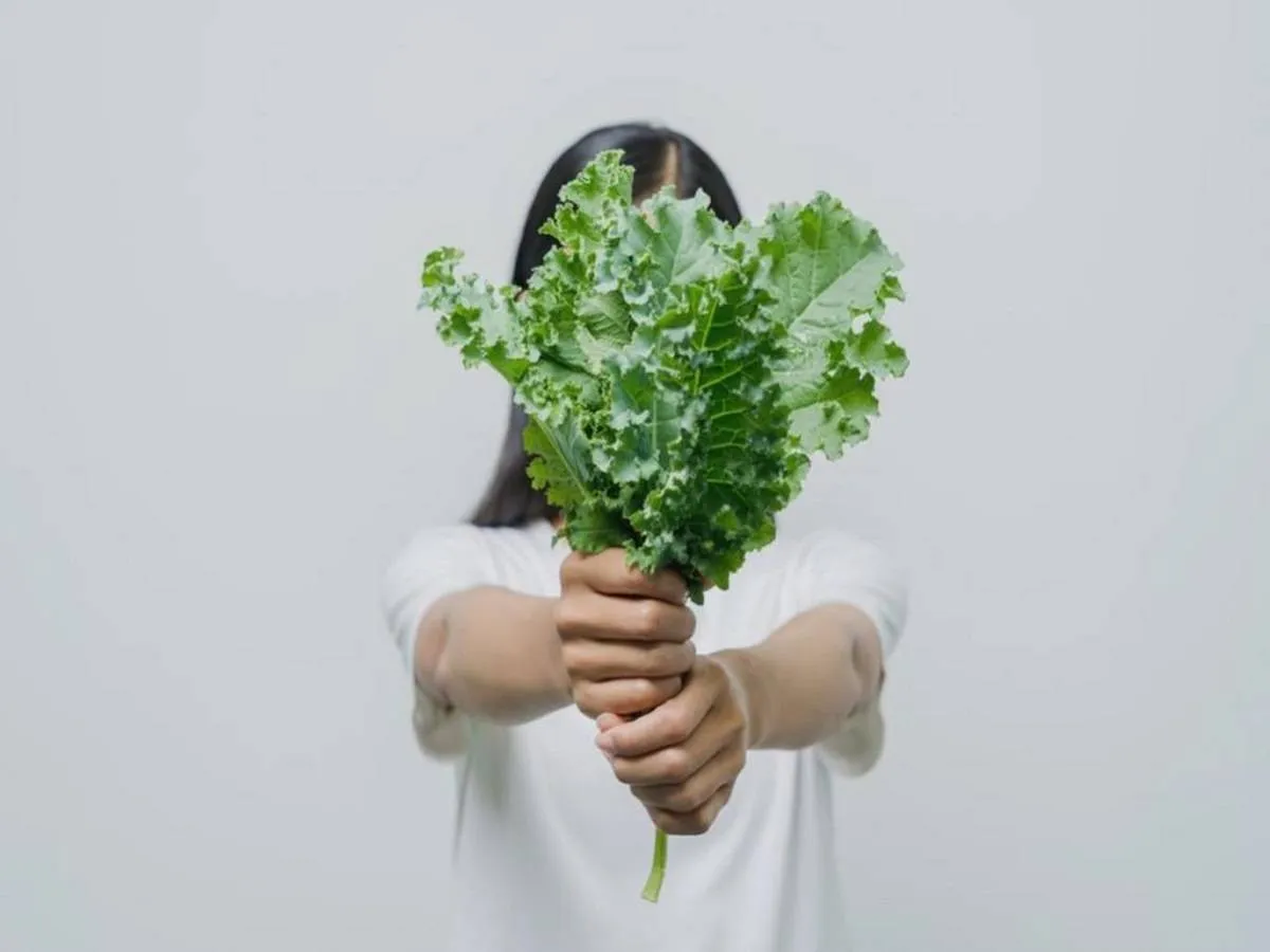 صورة لحامل تمسك بالخضروات الورقية