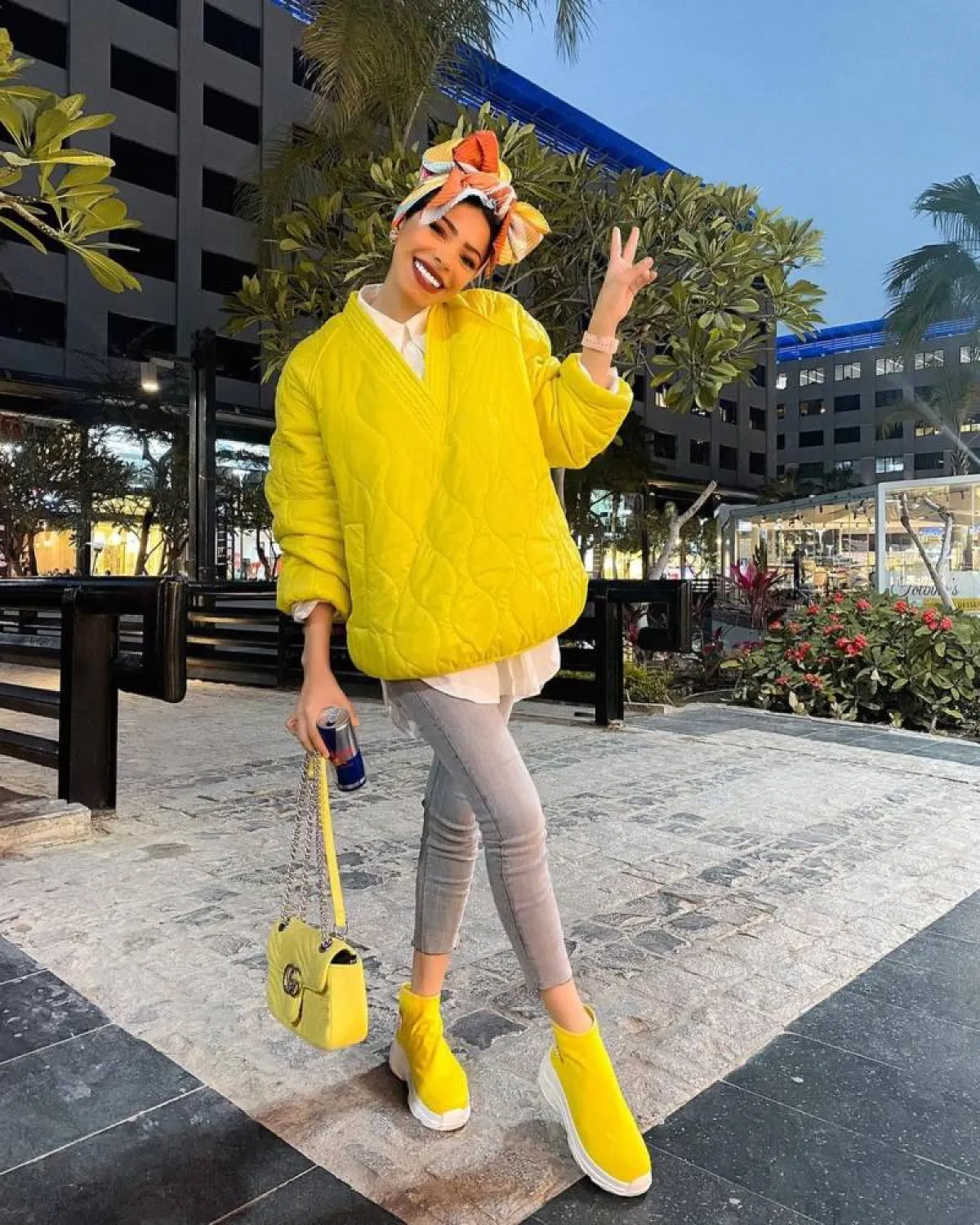 منة السُني ببلوفر أصفر وبنطلون جينز رمادي وحذاء أصفر