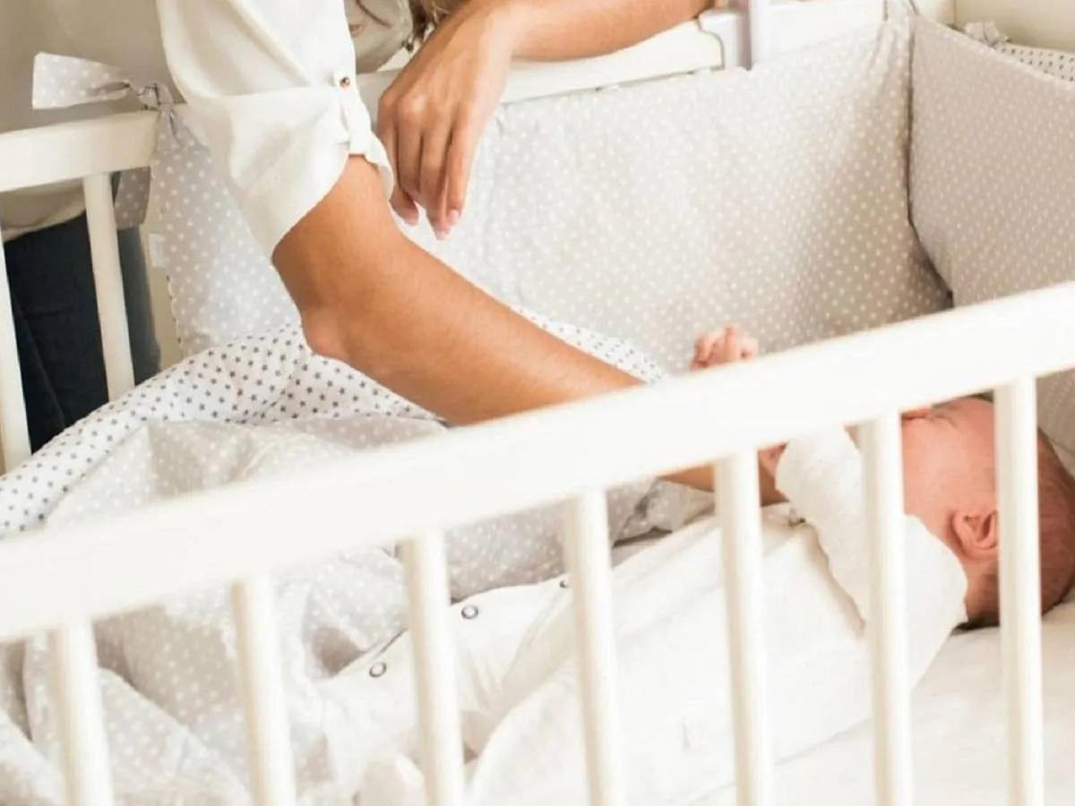 صورة لطفل رضيع نائم وأمه تحاول تهدئته