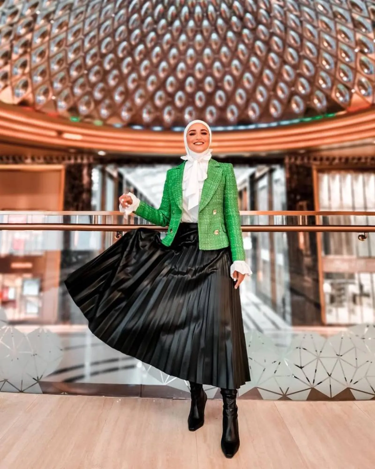 دلال الدوب بتنورة طويلة من الجلد الأسود، وبليزر أخضر