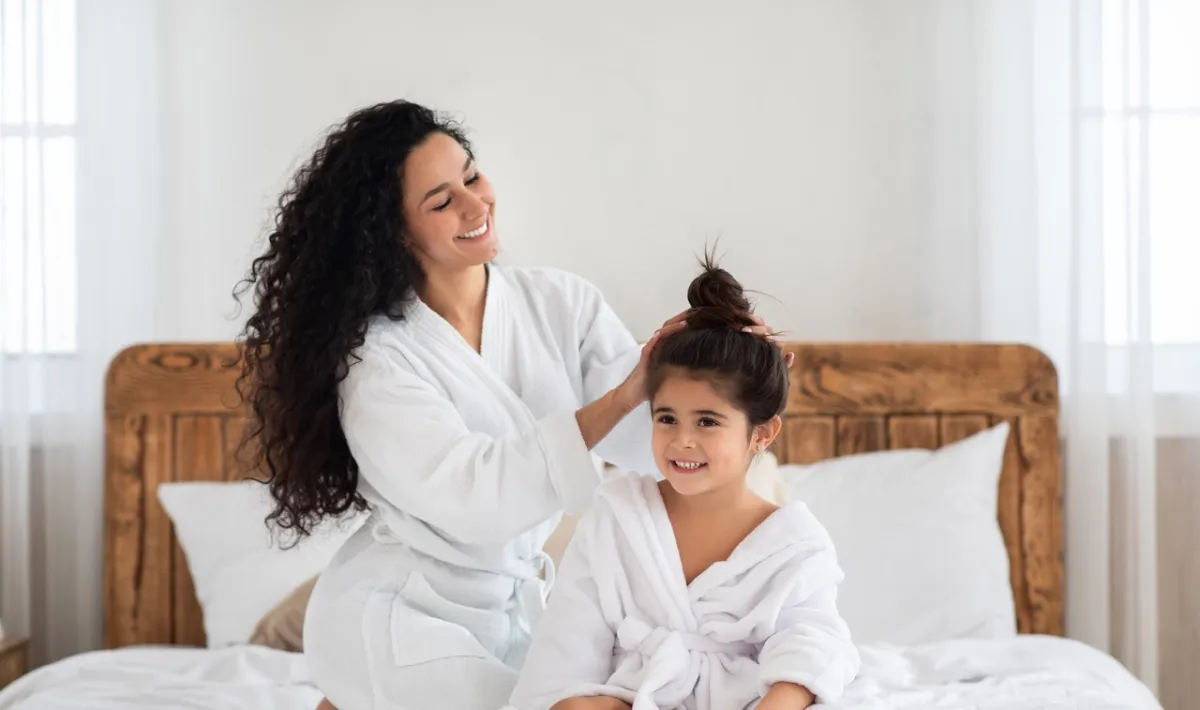 صورة لأم تسرح شعر ابنتها