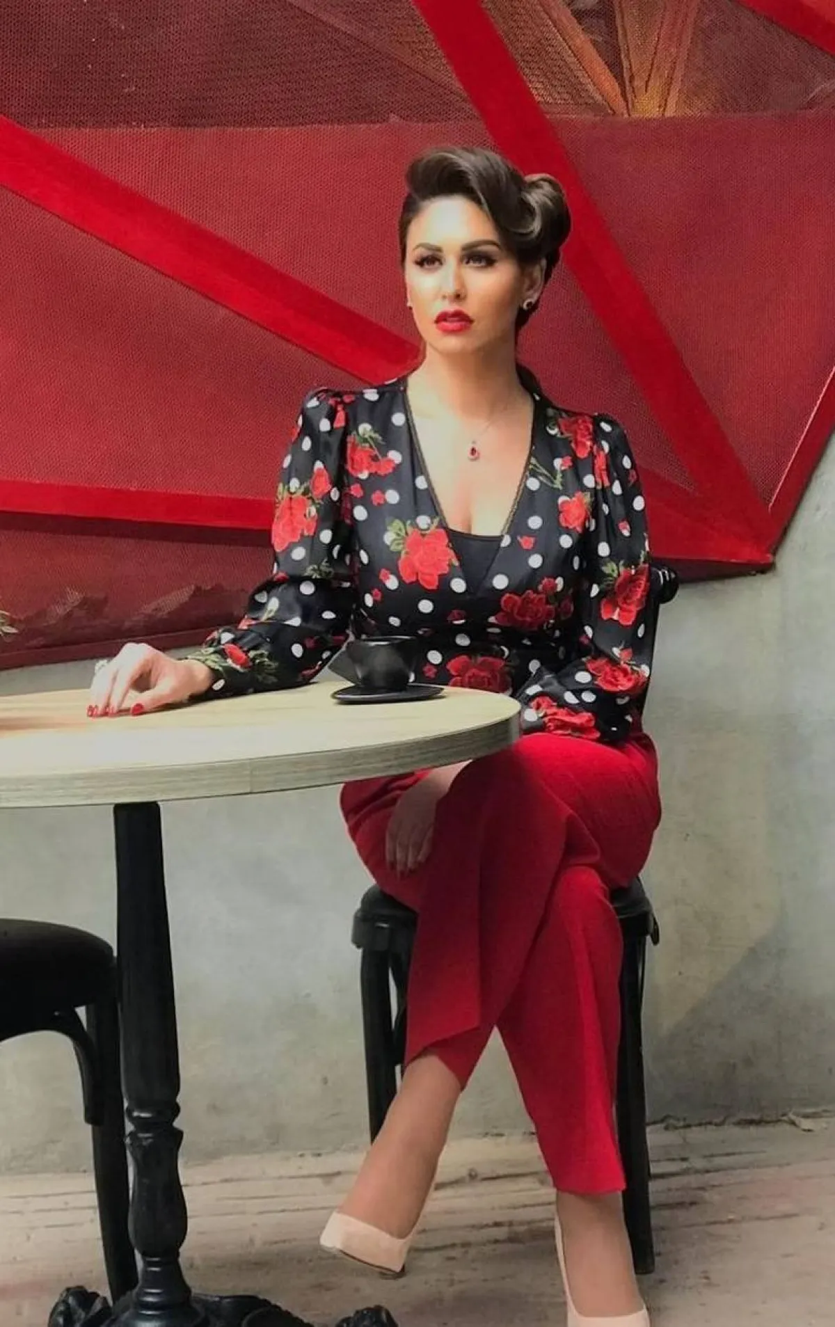 مي سليم ببنطلون أحمر وبلوزة سوداء مُطبعة بالورود