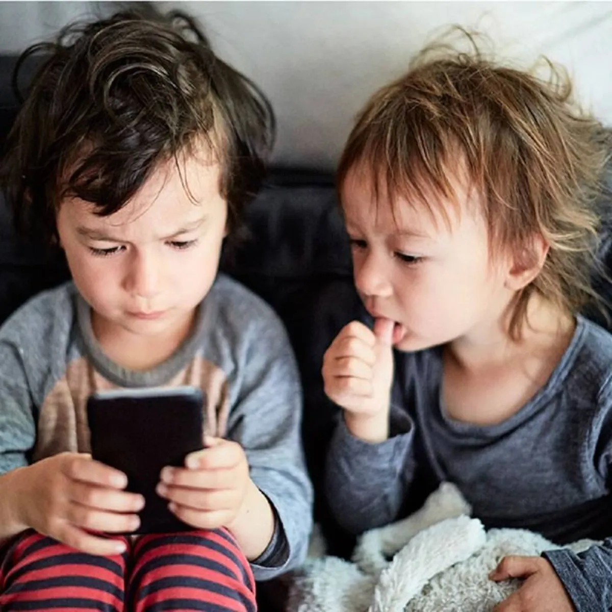 صورة لطفلين رضيعين وهاتف