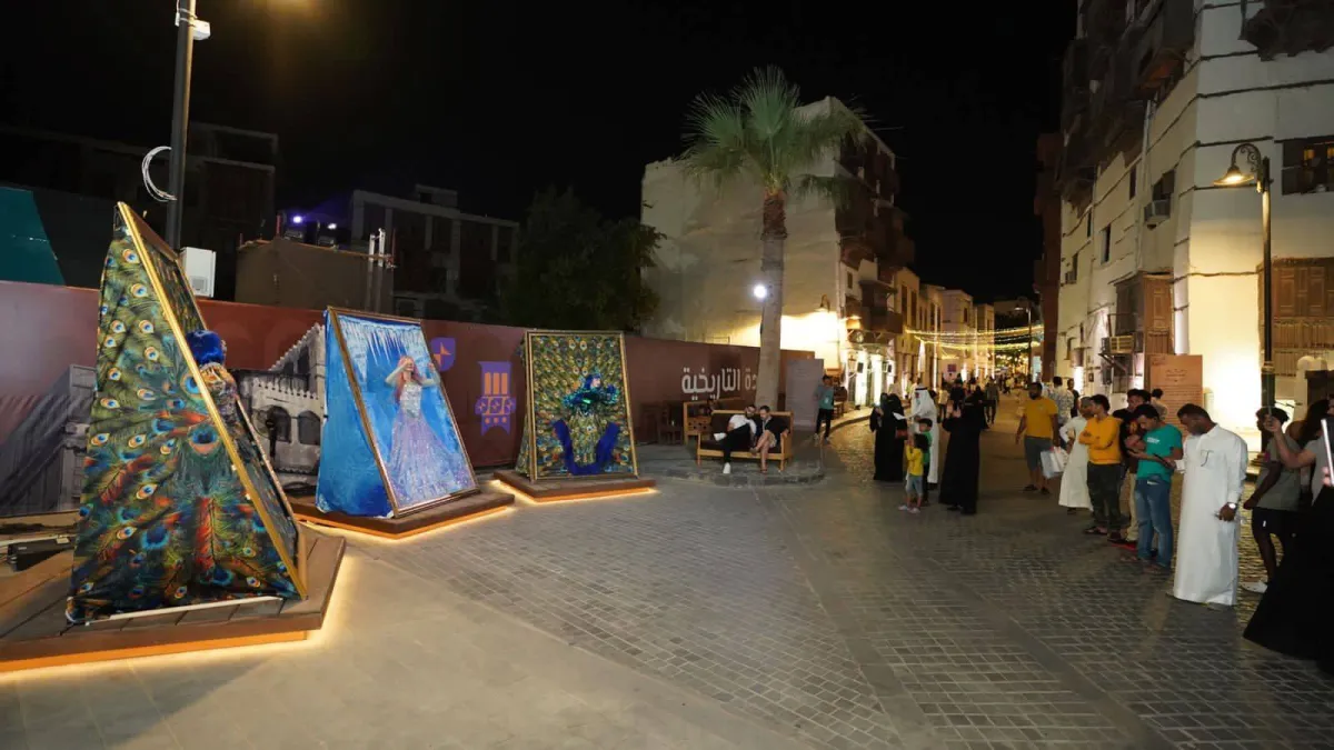 عدد من الزوار أمام الرسمة الحية