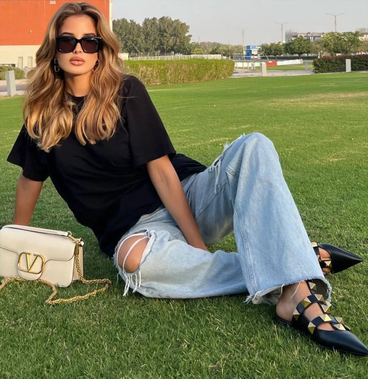 جوليا حسين بتوب أسود وبنطلون جينز ممزق باللون الأزرق الفاتح