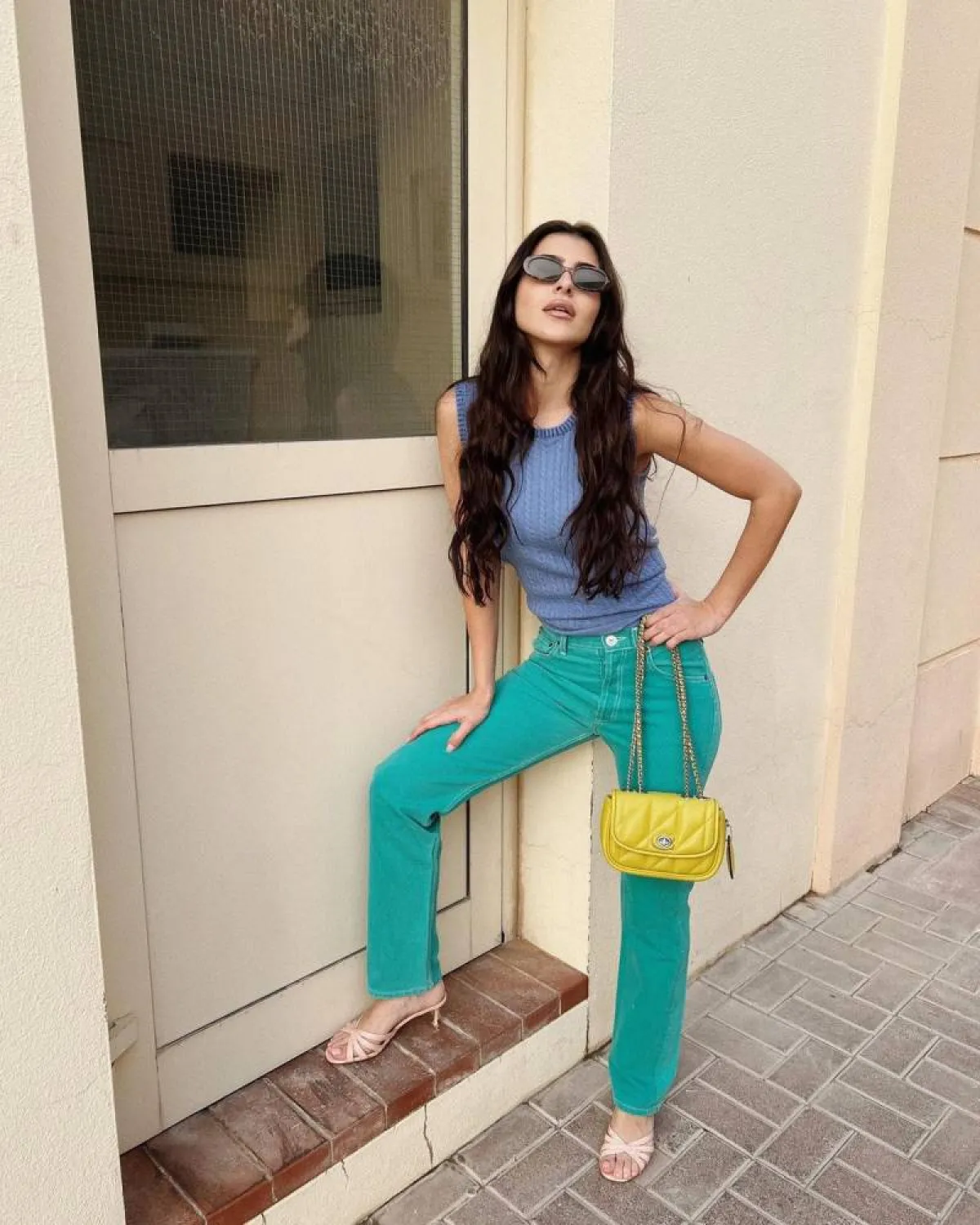 ديما الشيخلي بتوب أزرق ضيق وبنطلون جينز باللون الأخضر