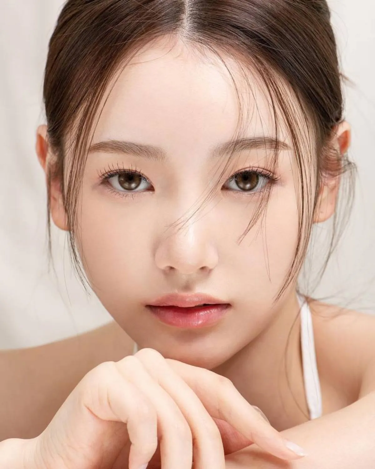 استخدمي الآيلاينر الأسود وظلال العيون الخوخي أو الوري لتطبيق مكياج كوري خفيف للمدرسة