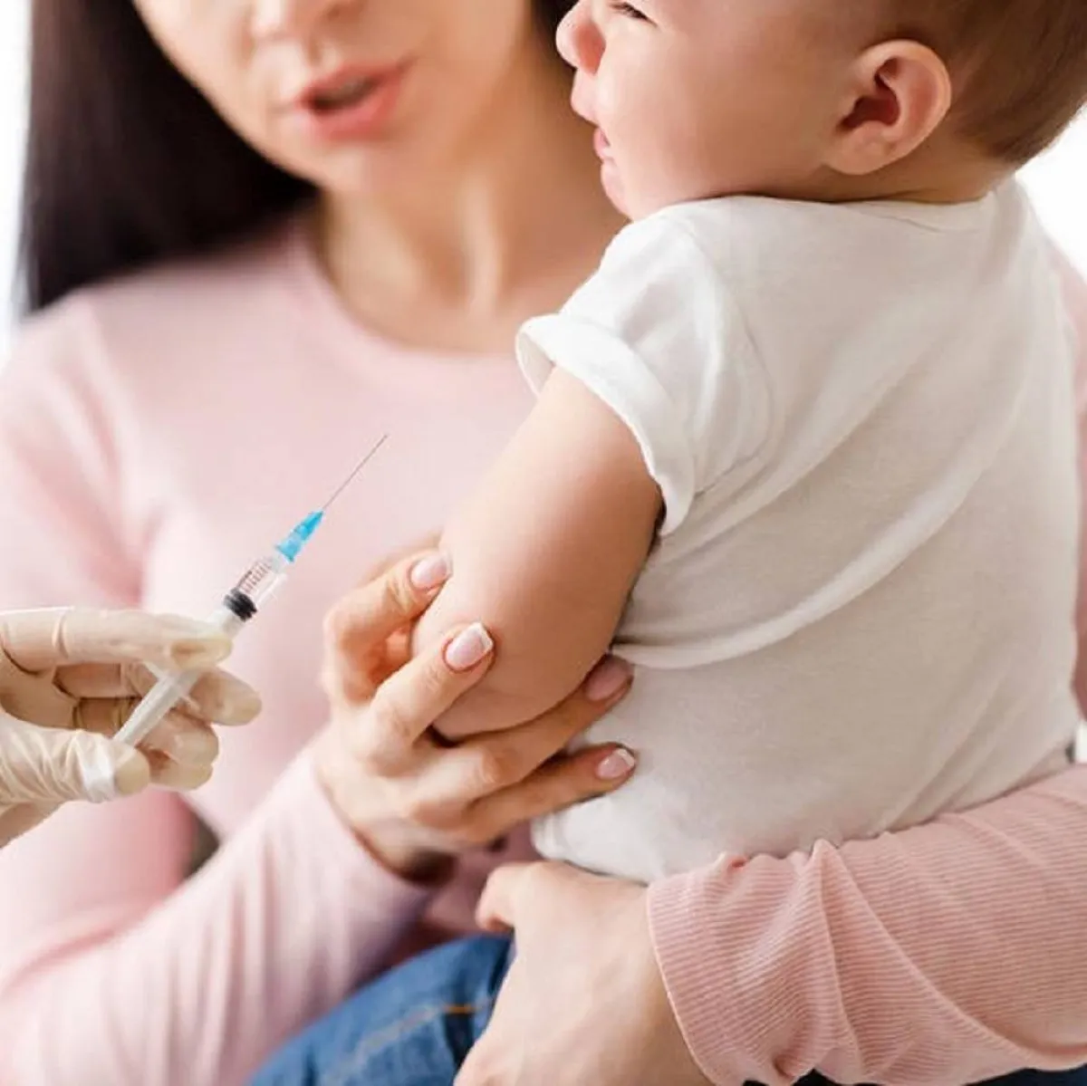 صورة لأم تحمل طفلها المريض