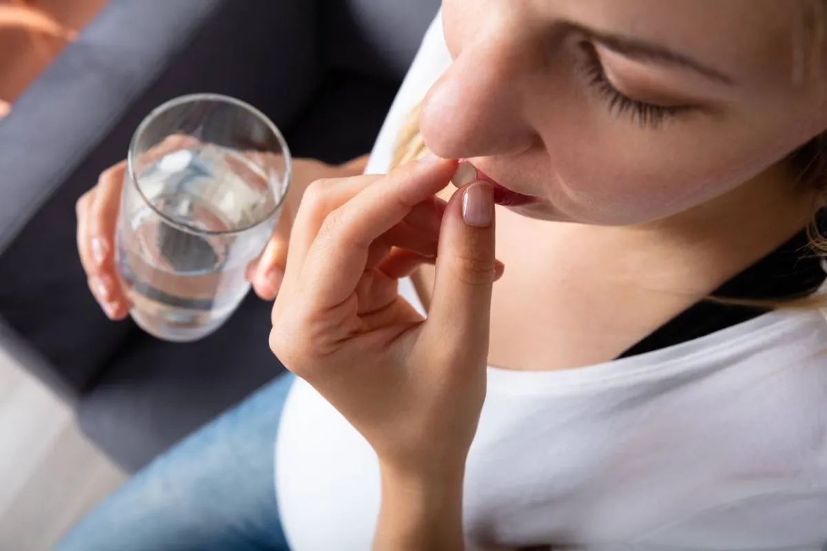 صورة لامرأة تتناول الدواء