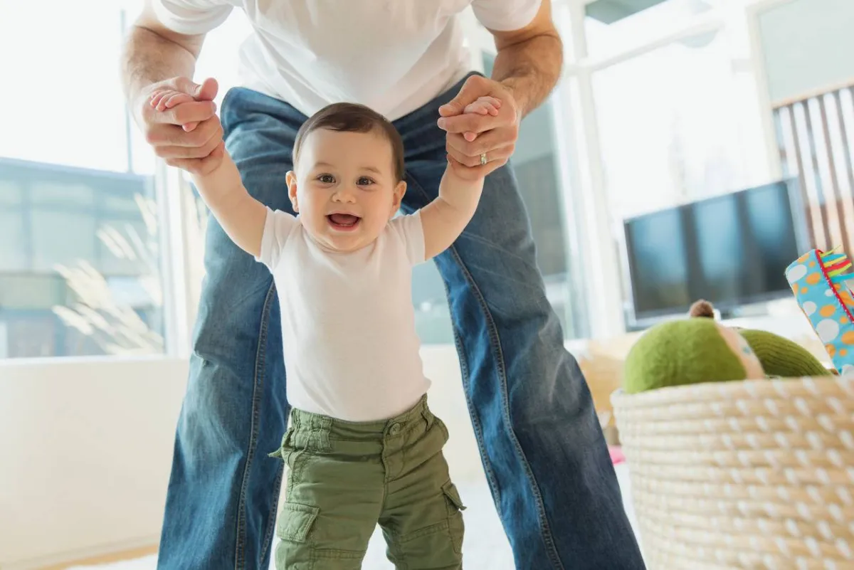 طفل يمشي بمساعدة أبيه