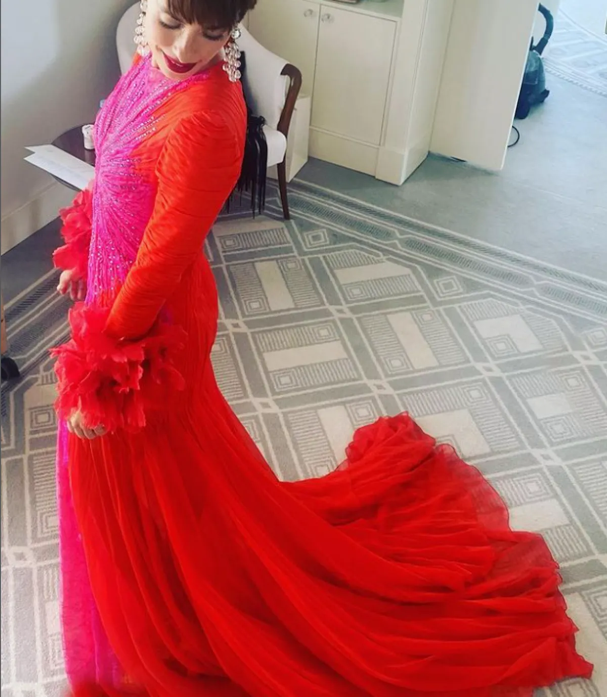 النجمة ريبيكا هال ترتدي فستاناً باللونين البنفسجي والأحمر 