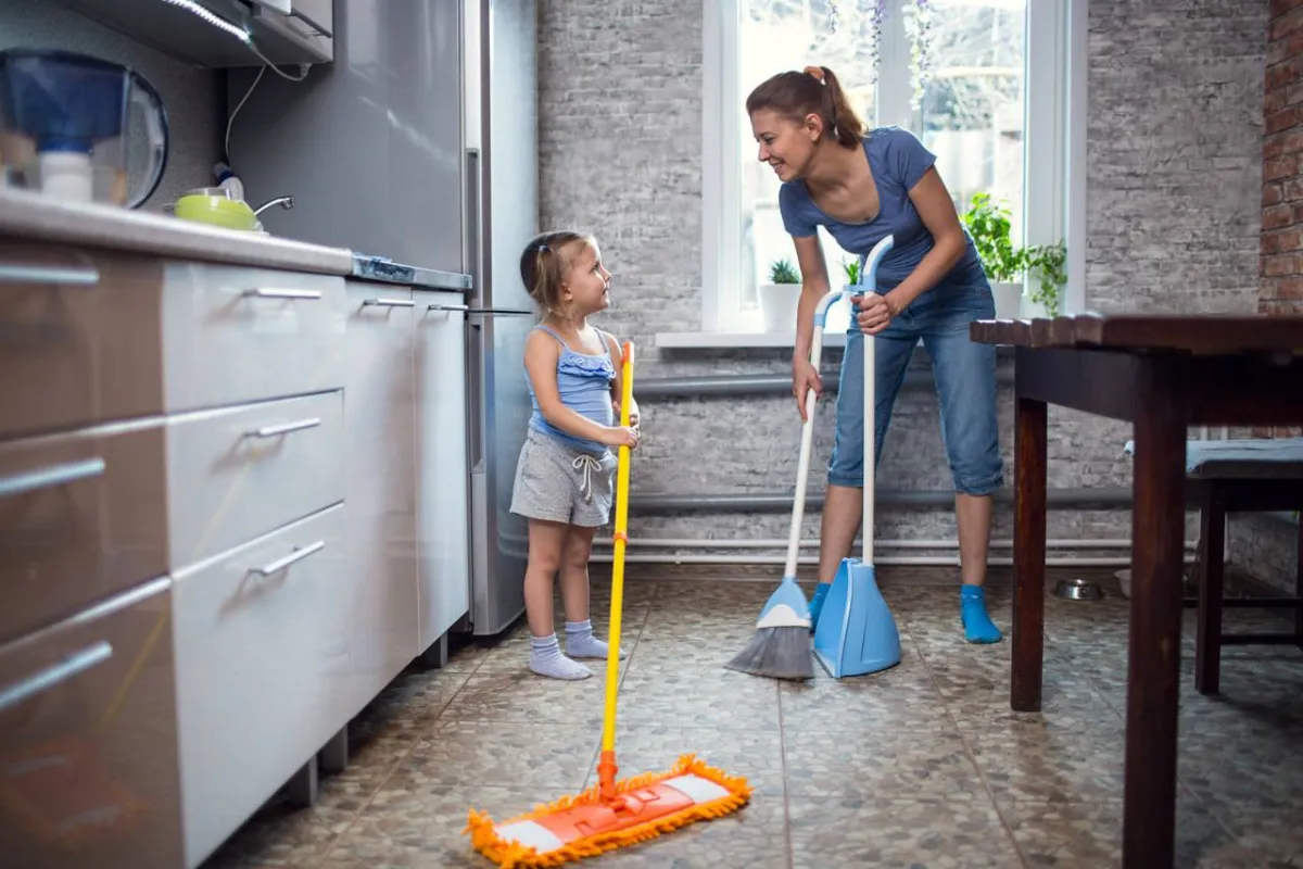 صورة لطفلة تساعد في تنظيف المطبخ