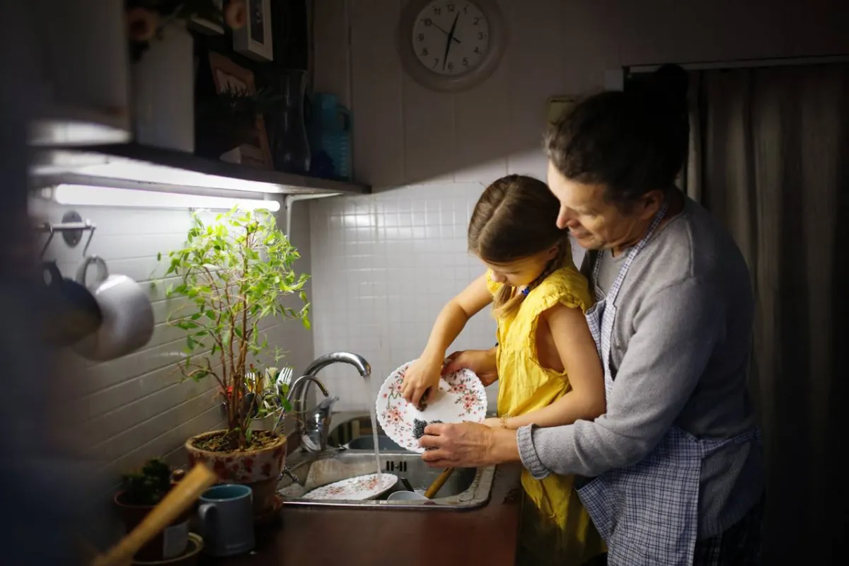 صورة لطفلة تغسل الصحون