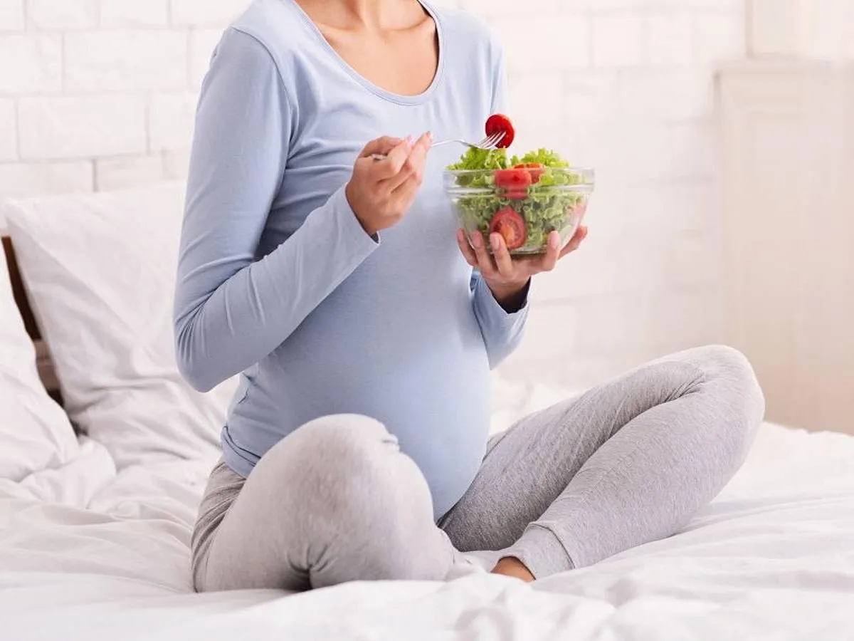 صورة لامرأة حامل تتناول الطعام