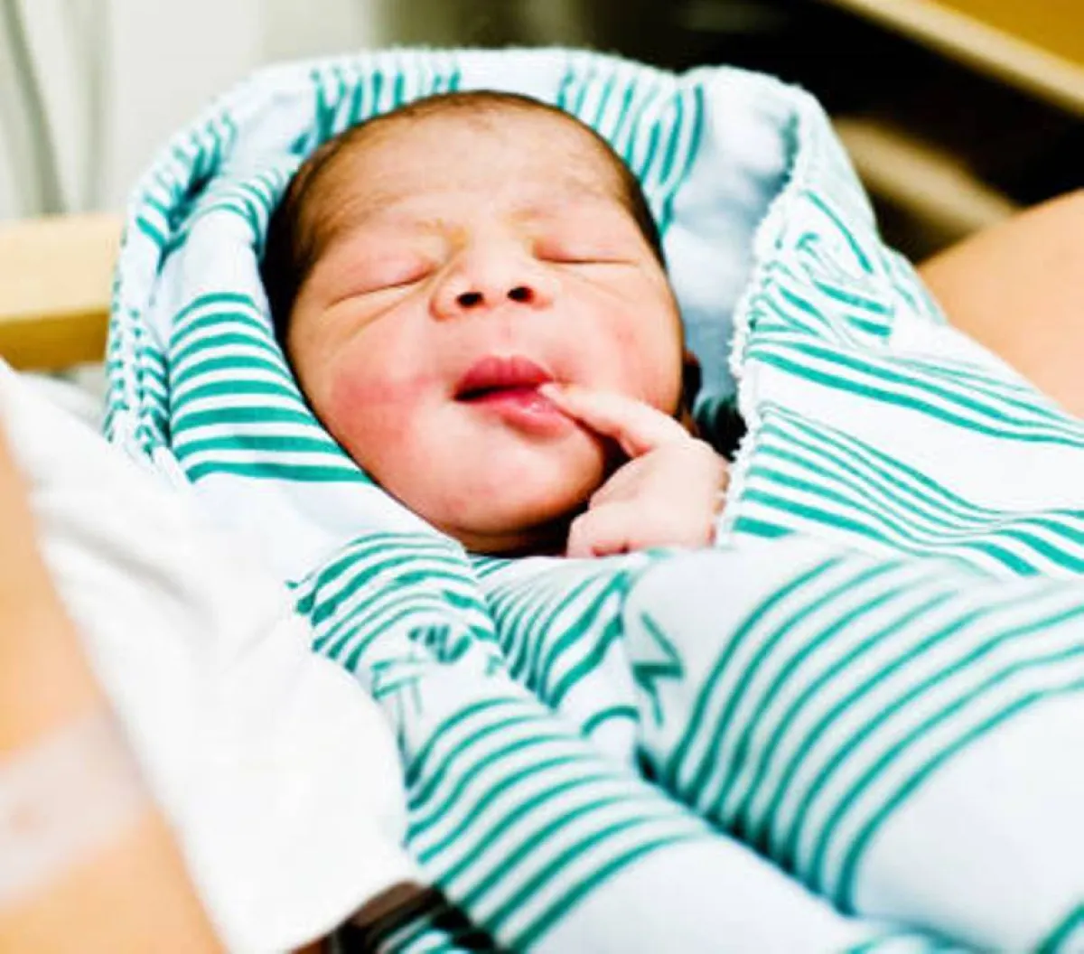 صورة لمولود يضع اصبعه في فمه