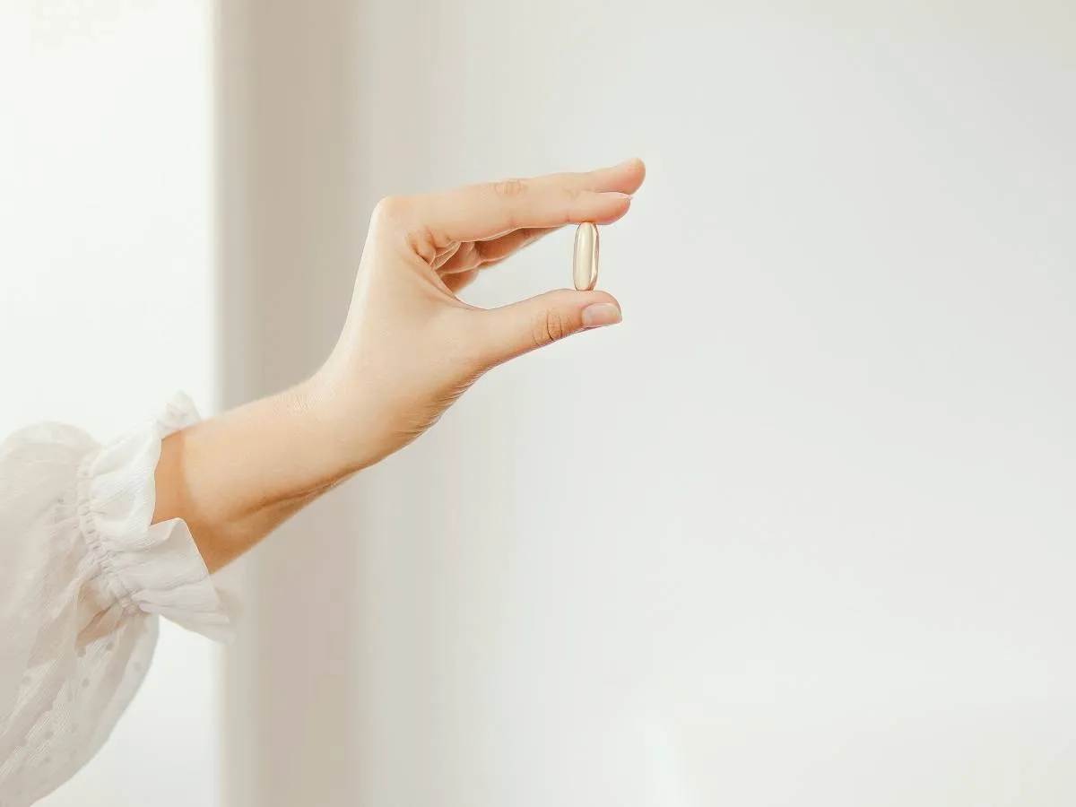 صورة لامرأة تمسك أقراص أوميغا 3