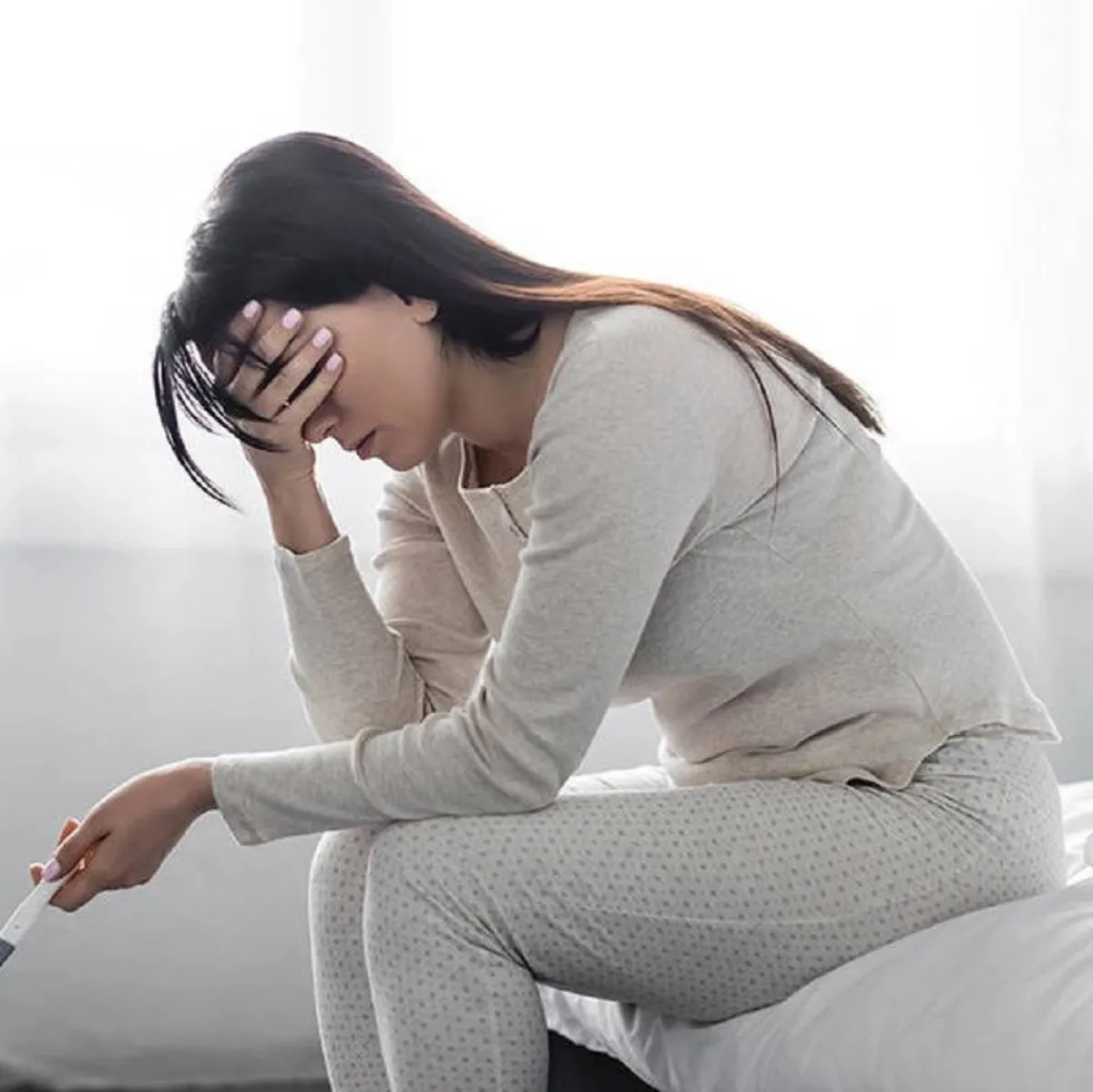 صورة لحامل ممسكة باختبار الحمل