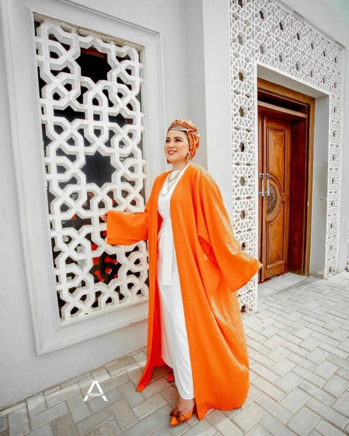 فاطمة نصر بعباية مفتوحة باللون البرتقالي النيون