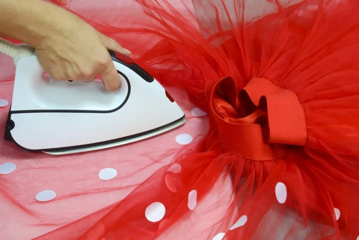 فستان أحمر مصنوع من التل ومحمّل بدوائر مصمّمة من الساتان 