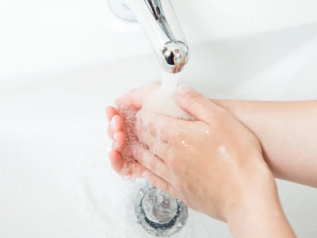 صورة لحامل تضع يديها تحت الماء