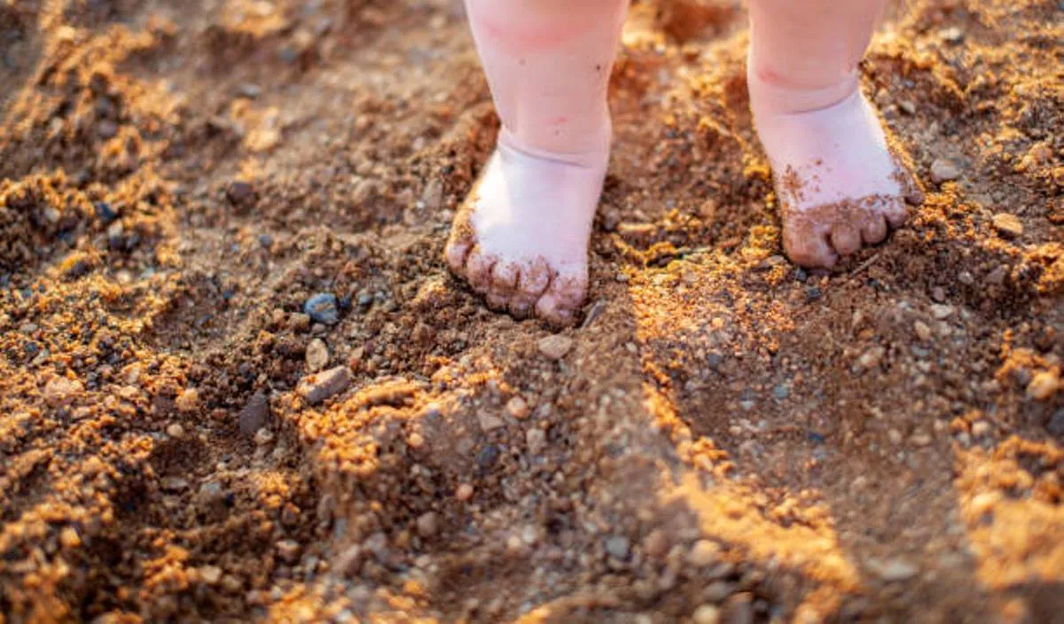 صورة لساقي طفل يمشي على الرمل