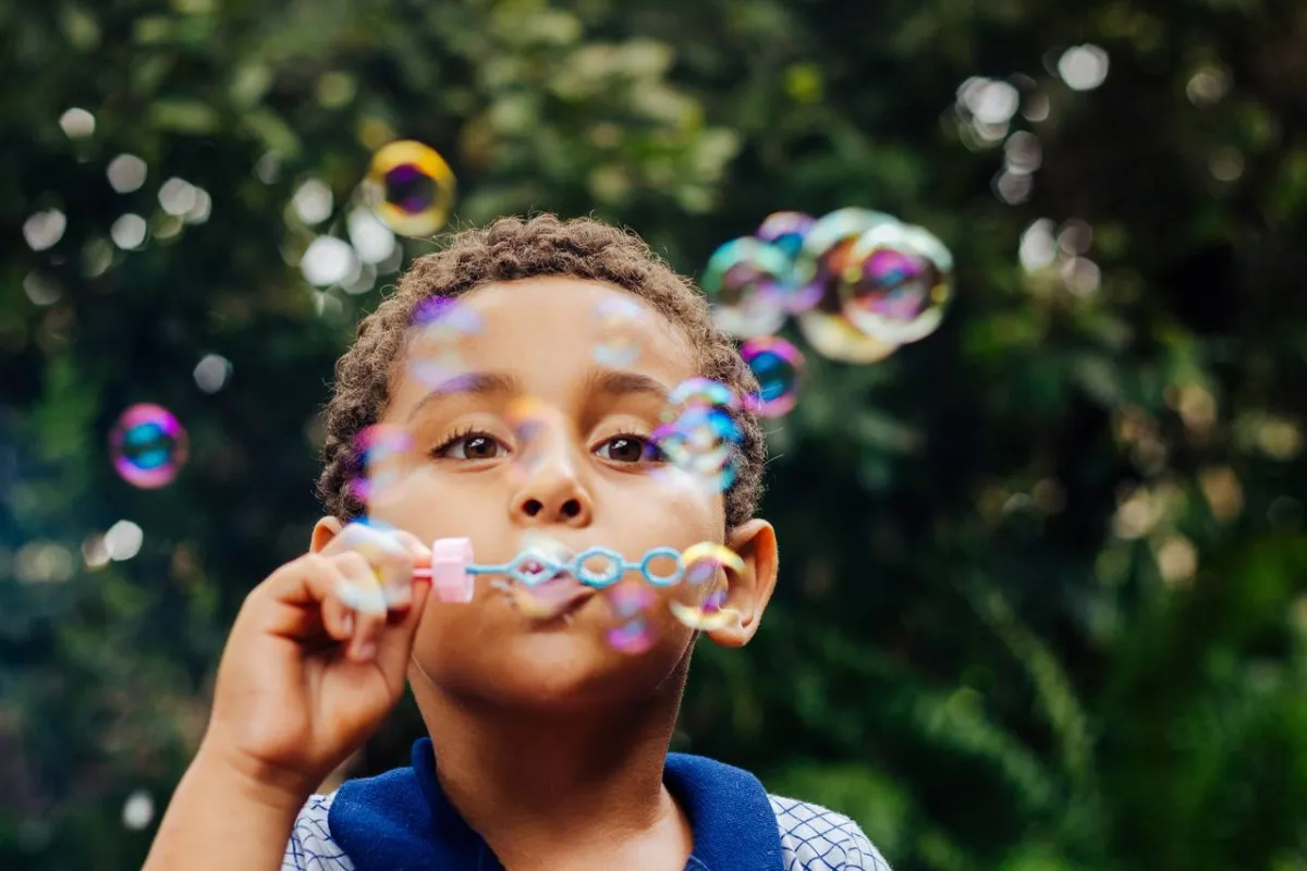 صورة طفل ينفخ الفقاعات