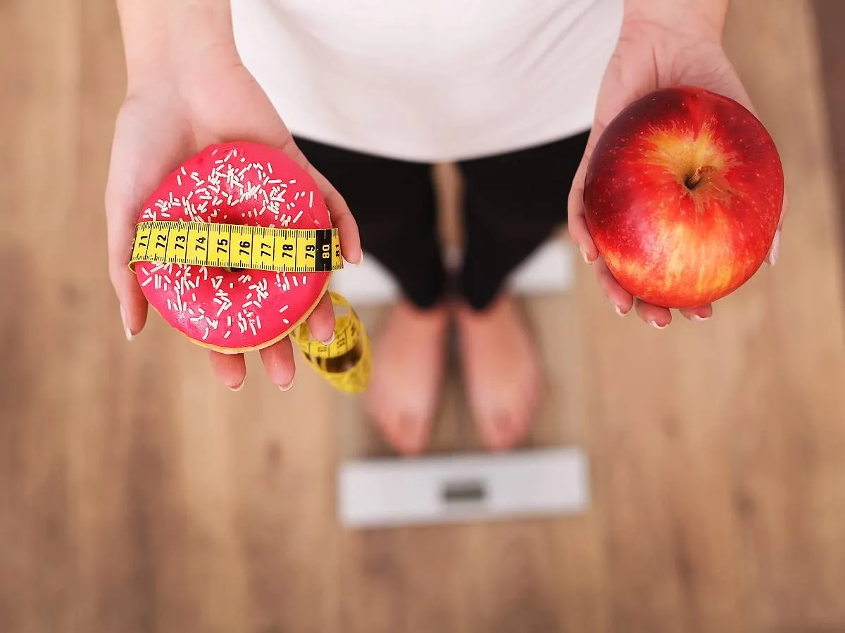 صورة لامرأة تحمل تفاحة ودونات