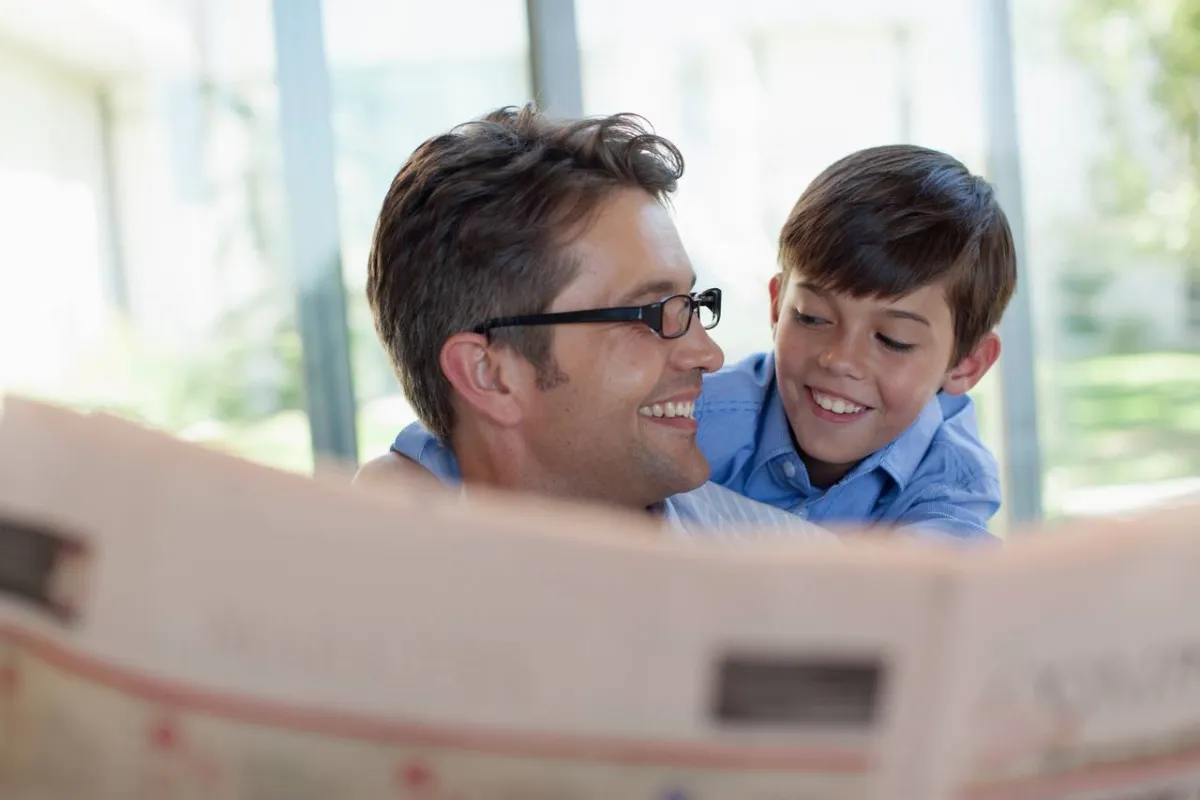 صورة طفل يقرأ الصحف مع والده