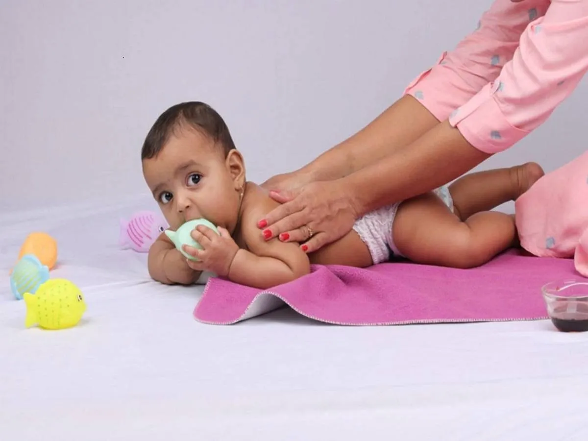 صورة لأم تقوم بتدليك الطفل