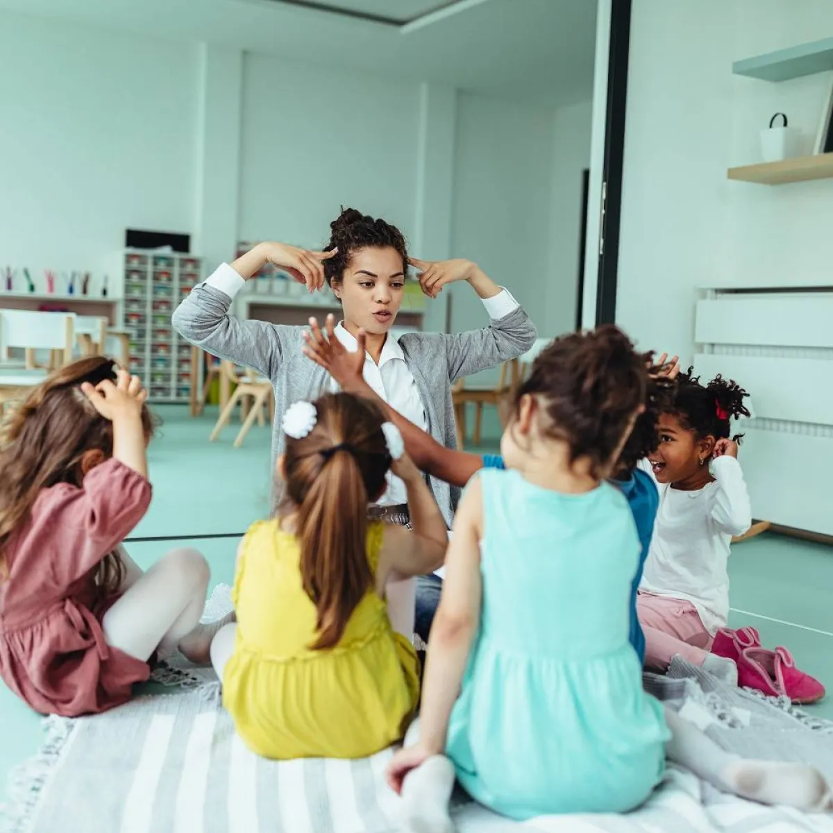 صورة لأطفال يلعبون مع معلمتهم