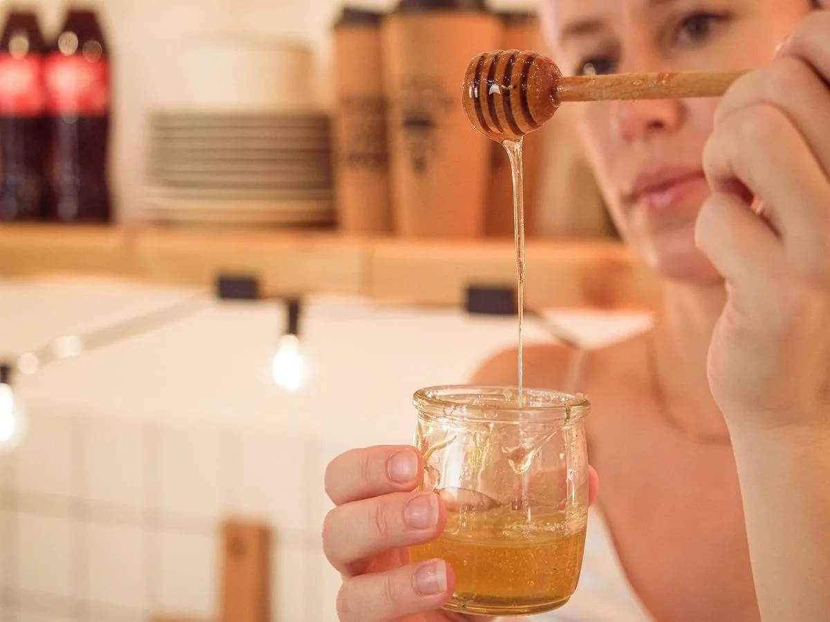 صورة لامرأة تتناول العسل