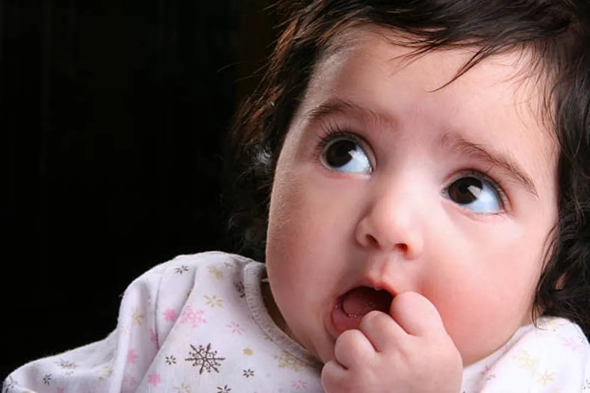 صورة لرضيع يضع يده في فمه