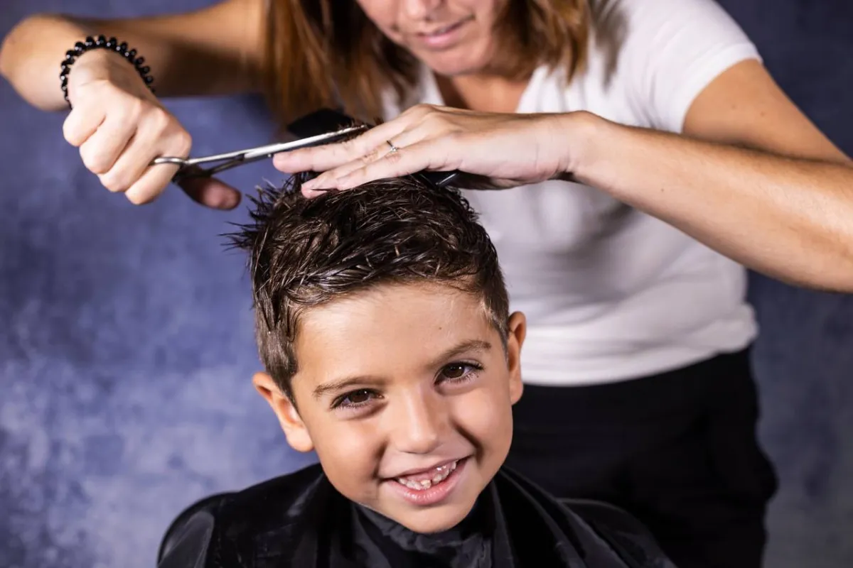 صورة لأم تقص شعر طفلها