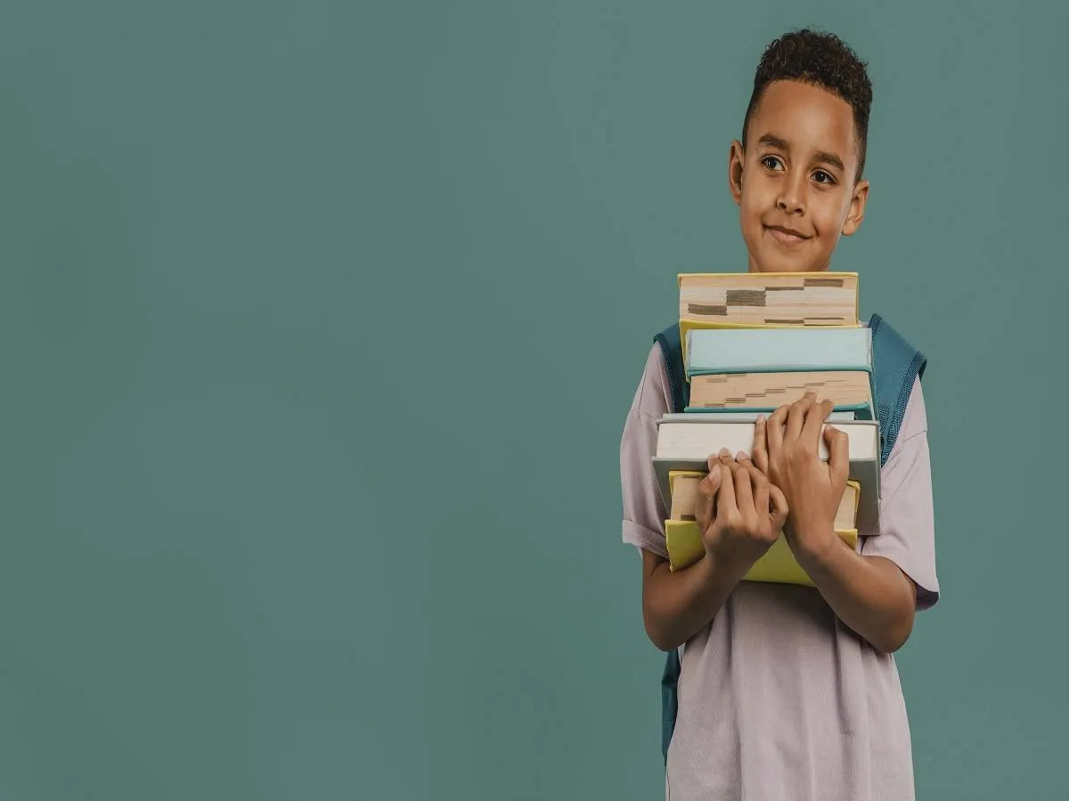 صورة لطفل يحمل كتب