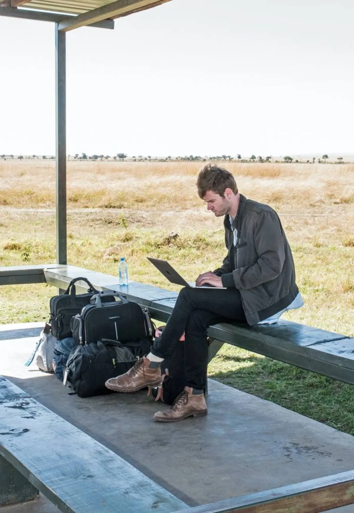 صورة شاب يعمل على لاب توب في الشارع