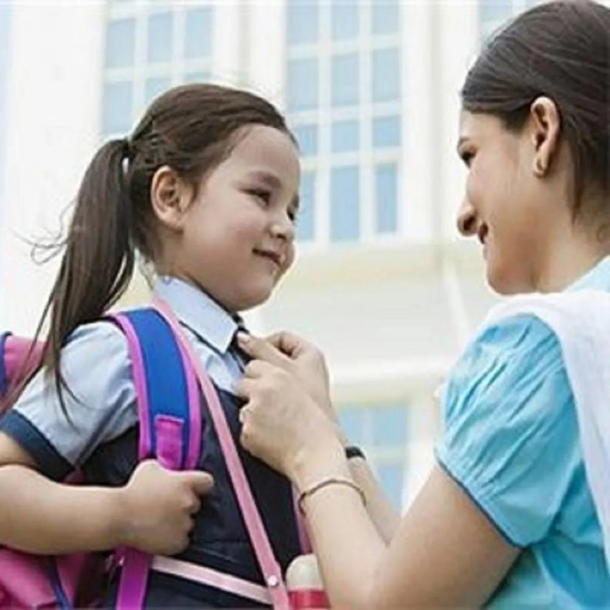 صورة لأم تعد طفلتها لرياض الأطفال