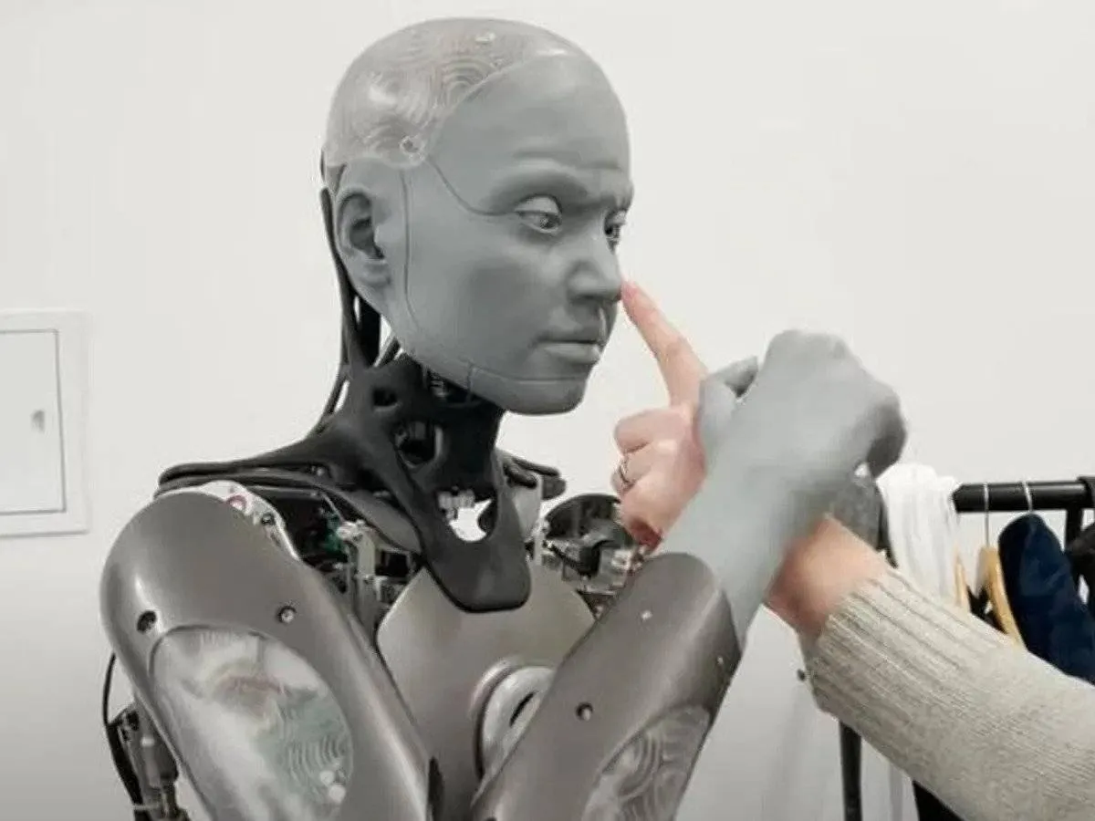 صورة الروبوت أميكا يمسك يد باحث